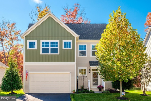 view of front of house with a garage, aphalt driveway, roof with shingles, a front lawn, and board and batten siding