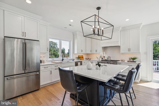 kitchen featuring plenty of natural light, white cabinetry, appliances with stainless steel finishes, and a breakfast bar area