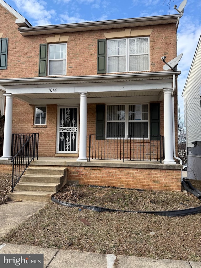 view of front of house featuring a porch and brick siding