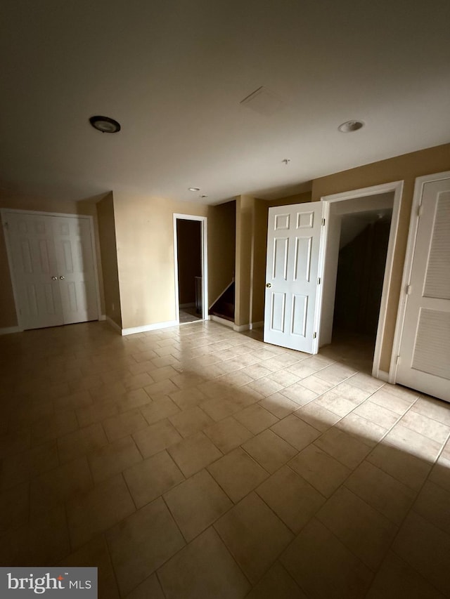 interior space with stairs, baseboards, and tile patterned flooring