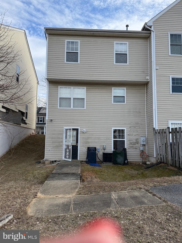 back of house with fence and central AC