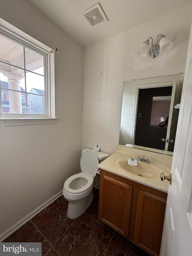 bathroom with vanity, toilet, baseboards, and visible vents