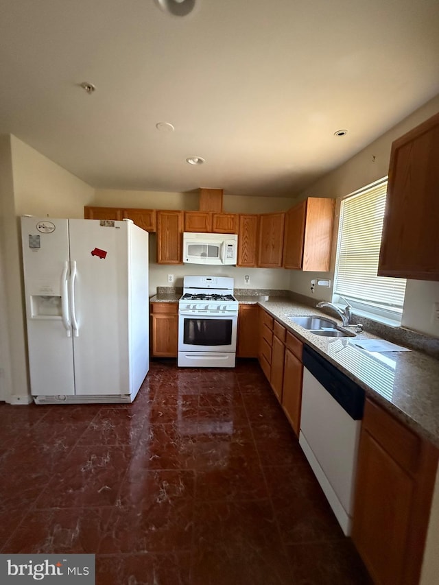 kitchen with white appliances, recessed lighting, brown cabinets, and a sink