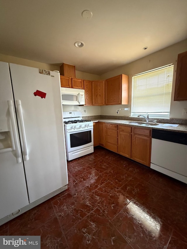 kitchen featuring a sink, white appliances, and recessed lighting