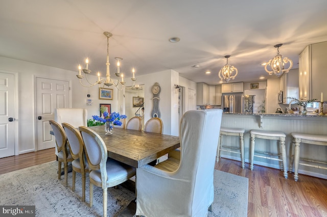 dining area featuring hardwood / wood-style floors and a notable chandelier