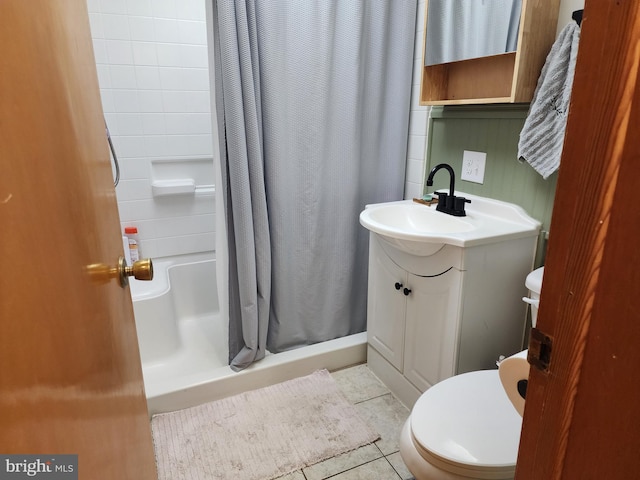 bathroom featuring toilet, a stall shower, tile patterned flooring, and vanity