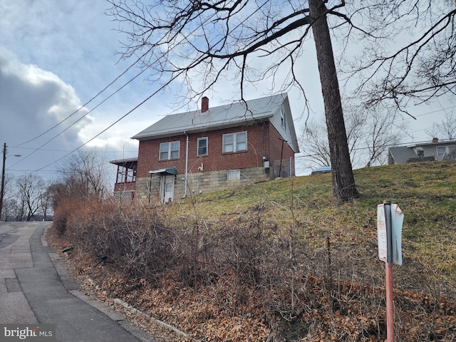 view of home's exterior featuring a chimney and brick siding