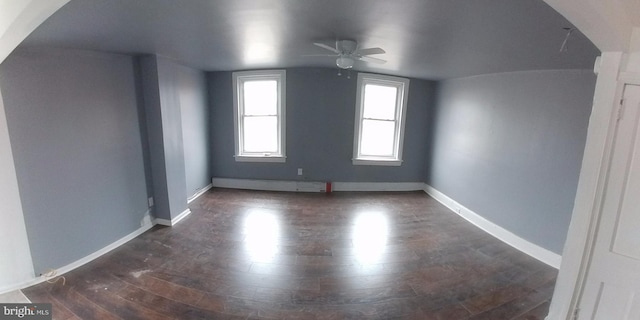 spare room with ceiling fan, vaulted ceiling, and dark hardwood / wood-style flooring