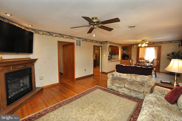 living area featuring visible vents, wood finished floors, and a ceiling fan