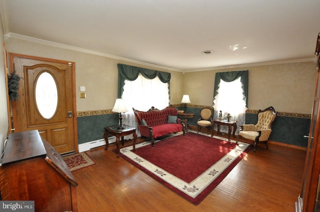 living area with plenty of natural light, baseboard heating, wood finished floors, and ornamental molding