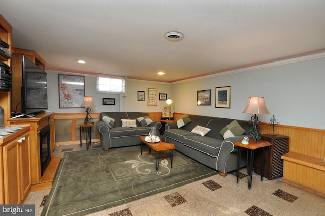 living area with wooden walls, visible vents, recessed lighting, ornamental molding, and wainscoting