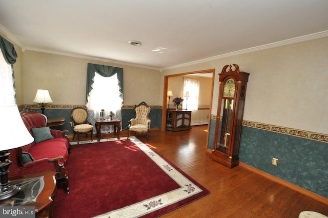 living area with visible vents, wood finished floors, ornamental molding, and a baseboard radiator