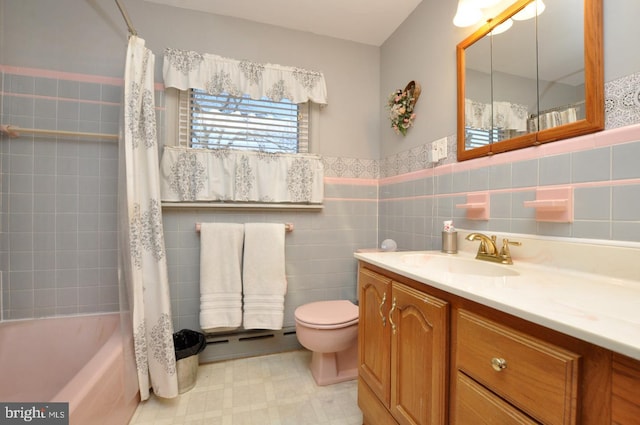 bathroom featuring vanity, wainscoting, tile walls, toilet, and tile patterned floors