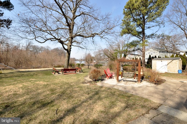 view of yard featuring a patio, an outbuilding, and a storage shed