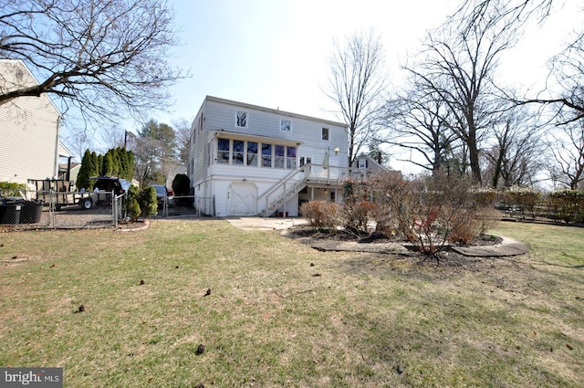 rear view of property featuring stairway, a yard, and fence