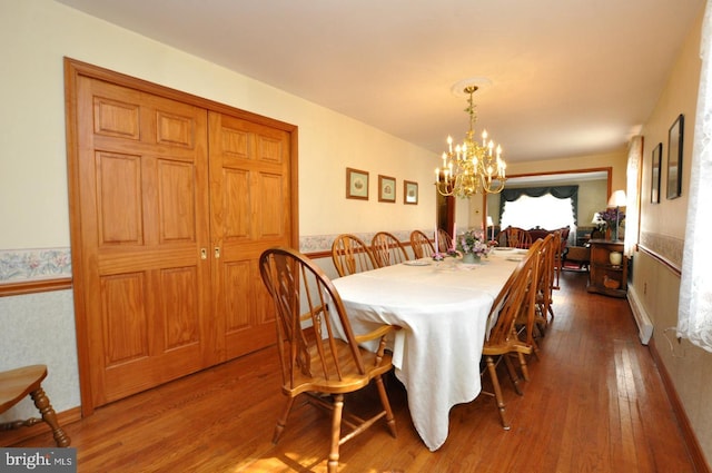 dining room featuring a chandelier, hardwood / wood-style floors, and wainscoting