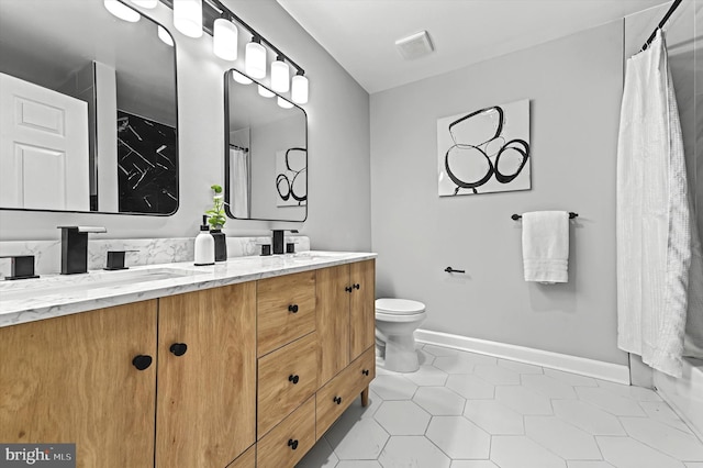 full bath with double vanity, visible vents, a sink, tile patterned flooring, and baseboards