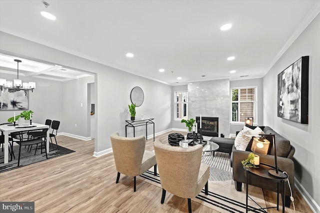 living room featuring light wood-style floors, ornamental molding, and a tiled fireplace