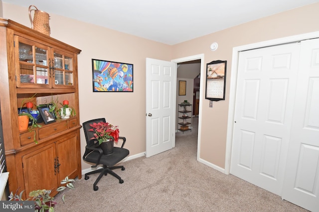 office area featuring light carpet and baseboards