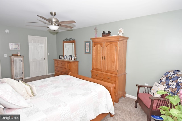 bedroom featuring light carpet, a ceiling fan, and baseboards