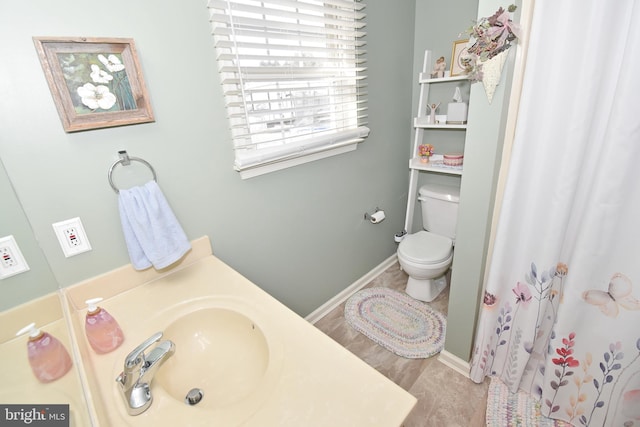 full bath with curtained shower, baseboards, a sink, and toilet