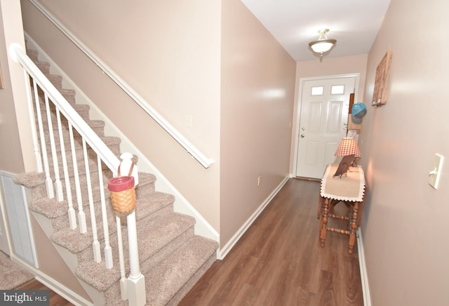 entryway featuring stairway, wood finished floors, and baseboards