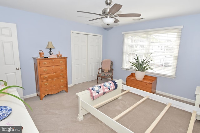 bedroom with ceiling fan, light colored carpet, visible vents, baseboards, and a closet