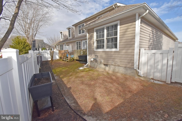 back of property with crawl space, fence private yard, and a garden