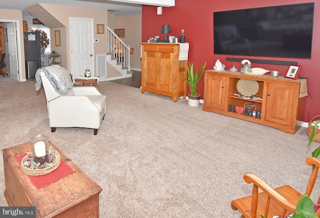 living area with carpet flooring, stairway, and baseboards