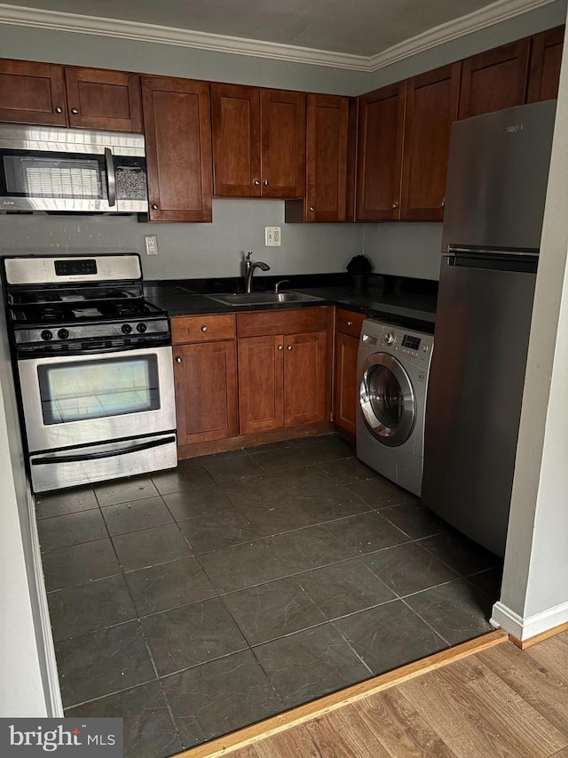 kitchen with appliances with stainless steel finishes, sink, crown molding, dark hardwood / wood-style flooring, and washer / clothes dryer