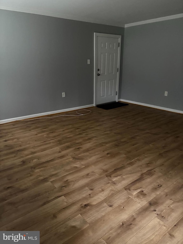 spare room with hardwood / wood-style flooring and crown molding