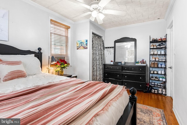 bedroom with a ceiling fan, ornamental molding, and wood finished floors