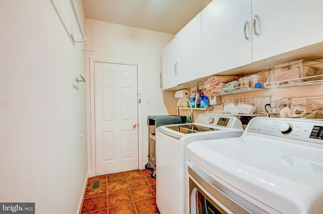 laundry area featuring cabinet space, baseboards, visible vents, dark tile patterned flooring, and washer and dryer