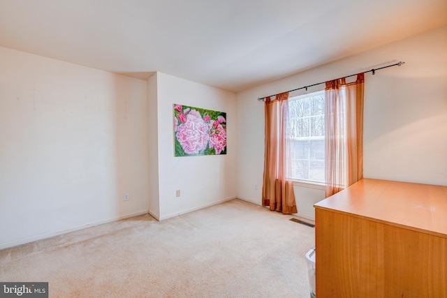 unfurnished office featuring baseboards, visible vents, and light colored carpet