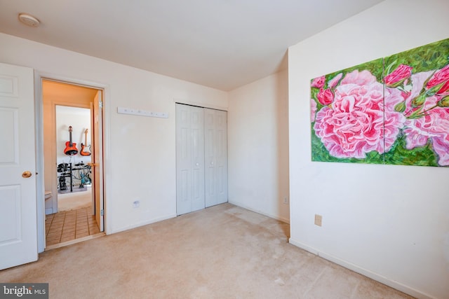 unfurnished bedroom with light carpet and baseboards