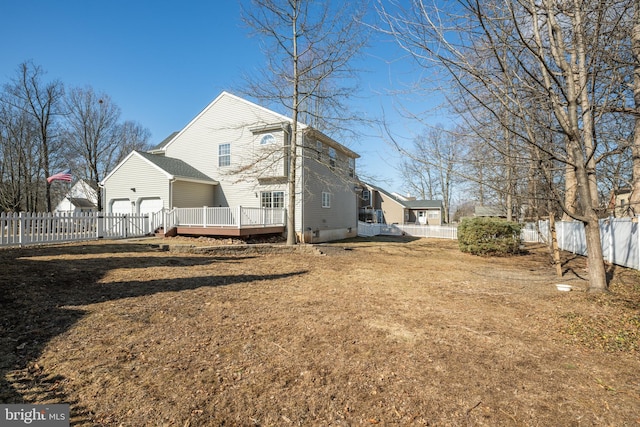 rear view of property with a garage, crawl space, a fenced backyard, and a lawn