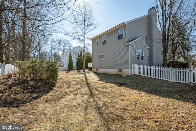 back of property with a yard, fence, and a chimney