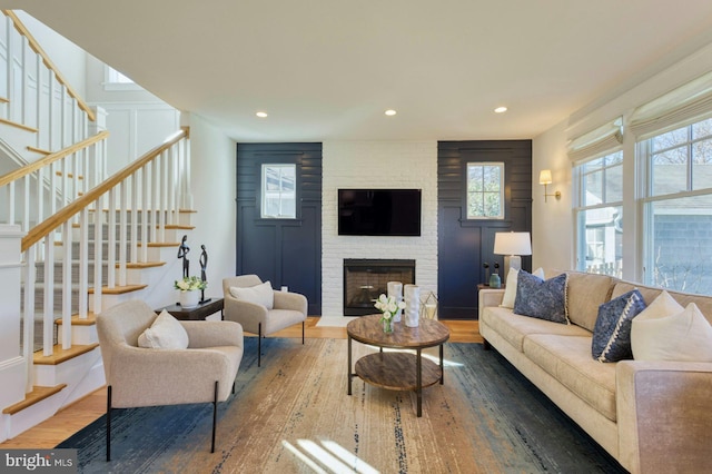 living room with a large fireplace, wood finished floors, a wealth of natural light, and recessed lighting