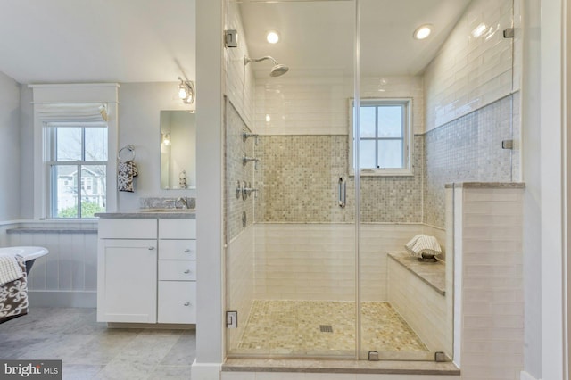 bathroom featuring a stall shower, vanity, and a healthy amount of sunlight