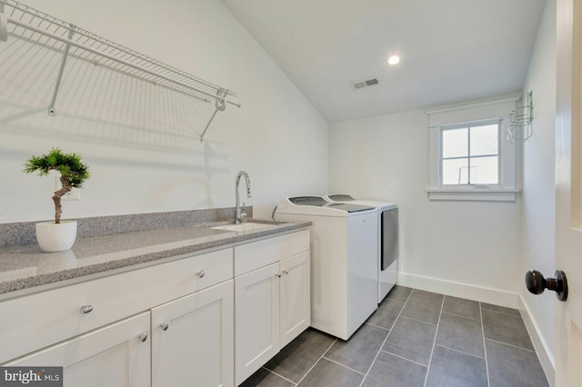 washroom featuring cabinet space, baseboards, visible vents, independent washer and dryer, and a sink