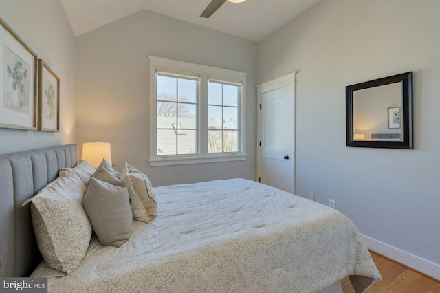 bedroom featuring lofted ceiling, ceiling fan, baseboards, and wood finished floors