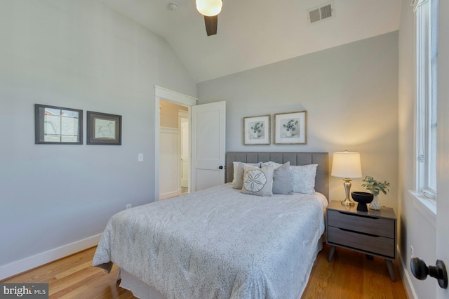 bedroom with lofted ceiling, wood finished floors, a ceiling fan, visible vents, and baseboards