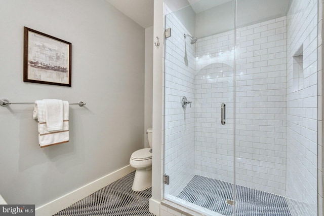 full bath featuring a shower stall, tile patterned flooring, toilet, and baseboards