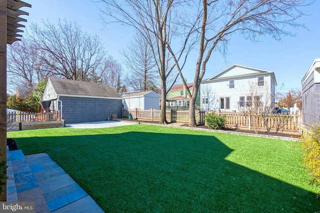 view of yard with a fenced backyard, a patio, and an outbuilding