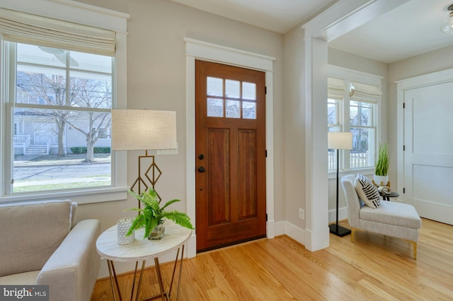 entryway featuring plenty of natural light, light wood-type flooring, and baseboards