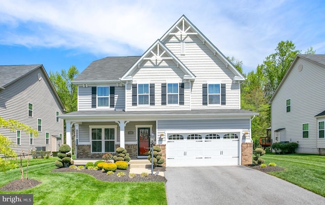 craftsman-style house featuring a porch, a front yard, aphalt driveway, and a garage