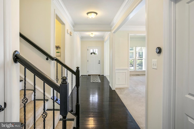 foyer entrance with stairway, crown molding, carpet, baseboards, and hardwood / wood-style flooring