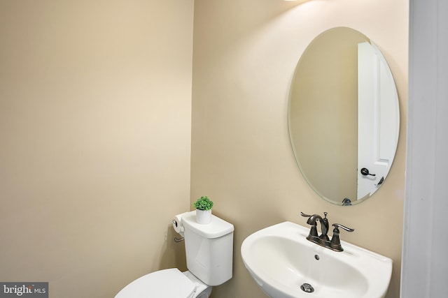 half bathroom featuring toilet and a sink
