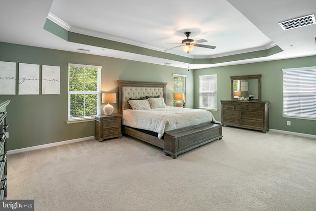 bedroom featuring a raised ceiling, crown molding, and visible vents