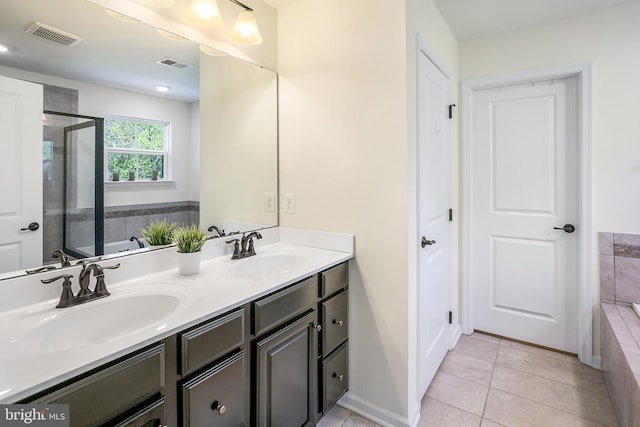 bathroom with visible vents, tile patterned flooring, a bath, and a sink